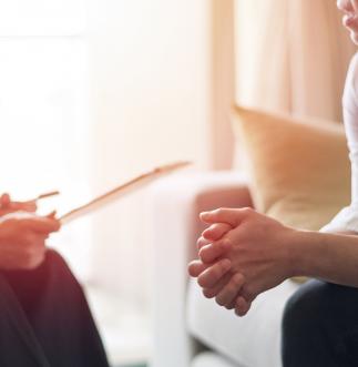 Two people sitting opposite each other in a counselling session